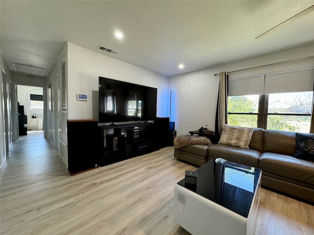 living room featuring a textured ceiling and light wood-type flooring