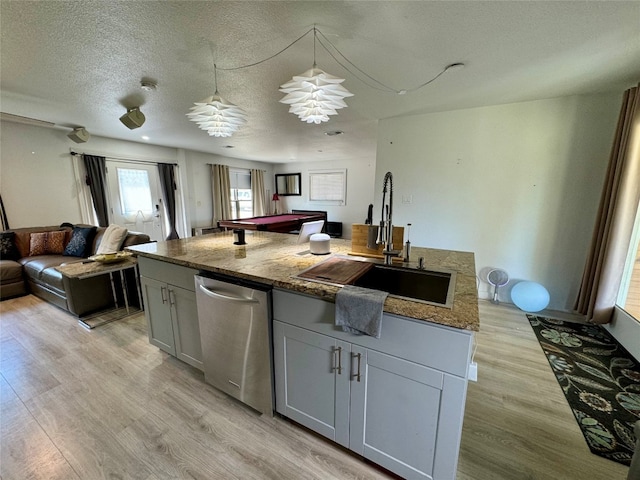 kitchen featuring sink, a textured ceiling, light hardwood / wood-style floors, stainless steel dishwasher, and pendant lighting