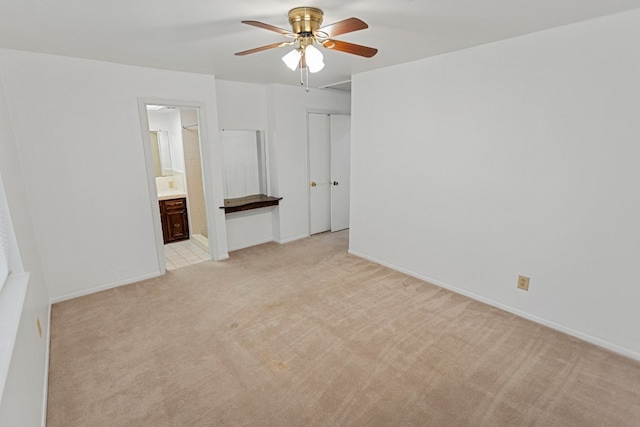 unfurnished bedroom featuring light carpet, ceiling fan, and ensuite bath