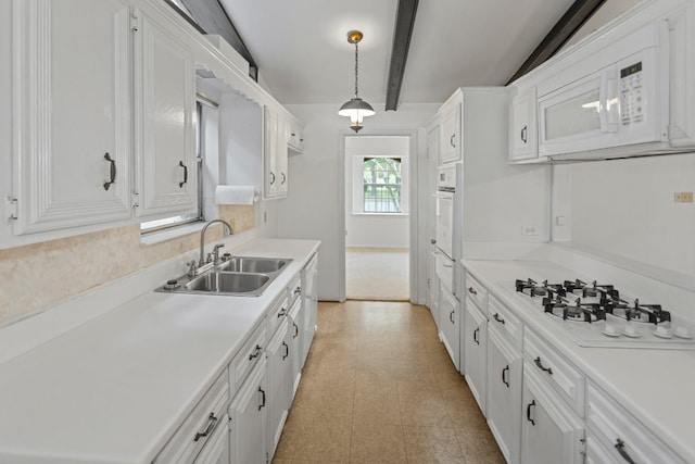 kitchen featuring white cabinets, hanging light fixtures, lofted ceiling with beams, sink, and white appliances