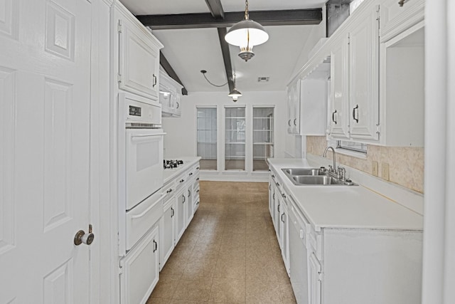 kitchen with beamed ceiling, backsplash, sink, white cabinetry, and white appliances