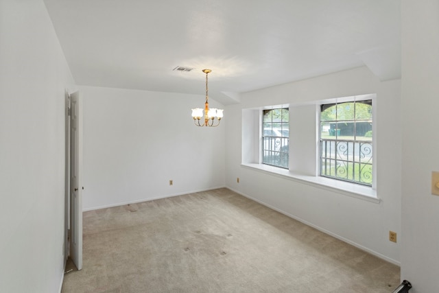 carpeted spare room with a chandelier