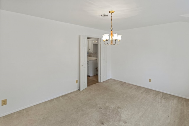 carpeted empty room featuring a notable chandelier