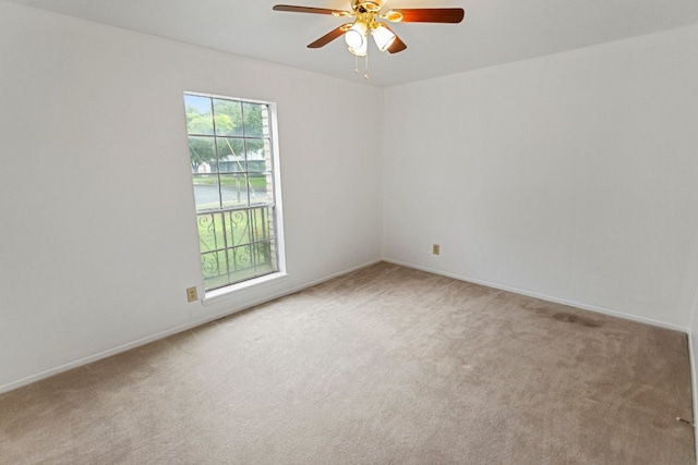 carpeted spare room featuring ceiling fan