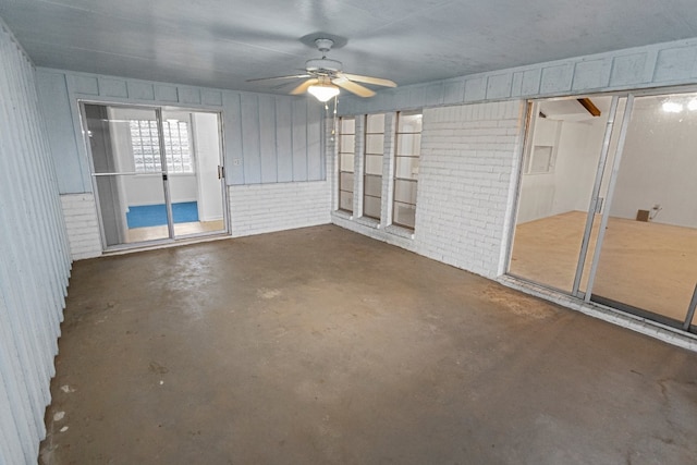 unfurnished sunroom with ceiling fan