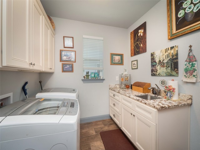 washroom featuring washing machine and dryer, sink, and cabinets