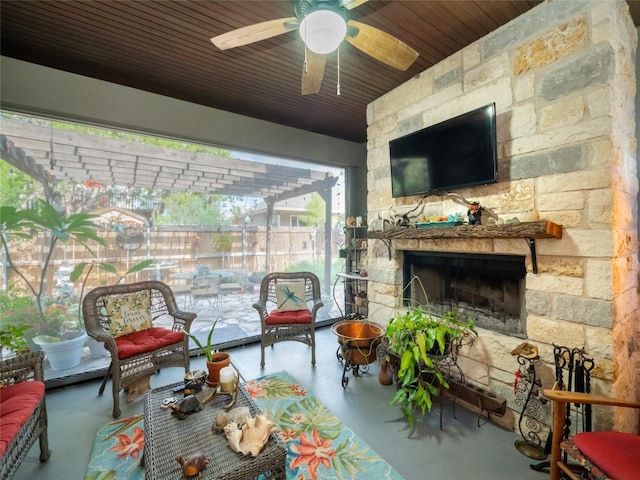 sunroom featuring a stone fireplace, wood ceiling, and ceiling fan