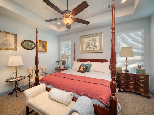 bedroom with ceiling fan, a raised ceiling, and carpet