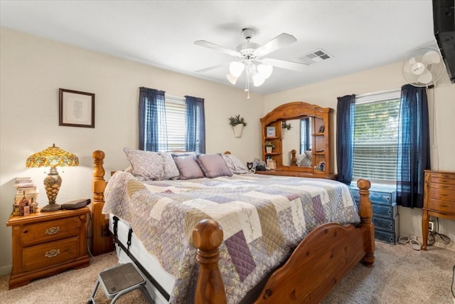 carpeted bedroom featuring multiple windows and ceiling fan