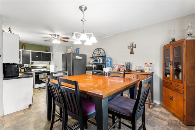 dining area with ceiling fan with notable chandelier