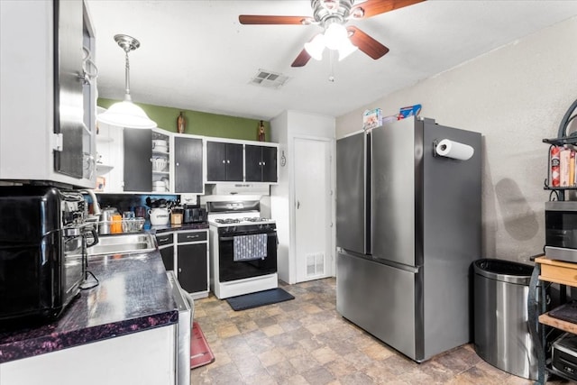 kitchen with gas range gas stove, ceiling fan, sink, pendant lighting, and stainless steel refrigerator