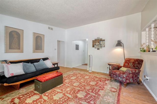 living room featuring a textured ceiling and light wood-type flooring