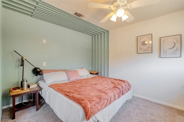 bedroom with a textured ceiling, light colored carpet, and ceiling fan