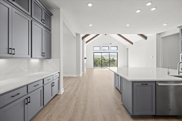 kitchen with gray cabinetry, dishwasher, lofted ceiling with beams, ceiling fan, and light wood-type flooring