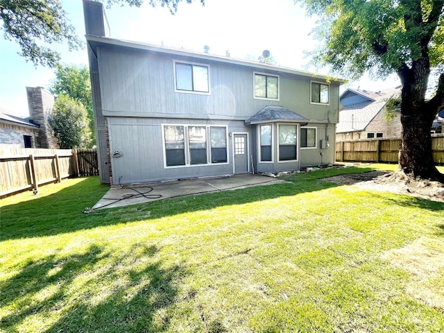 rear view of house with a patio area and a lawn