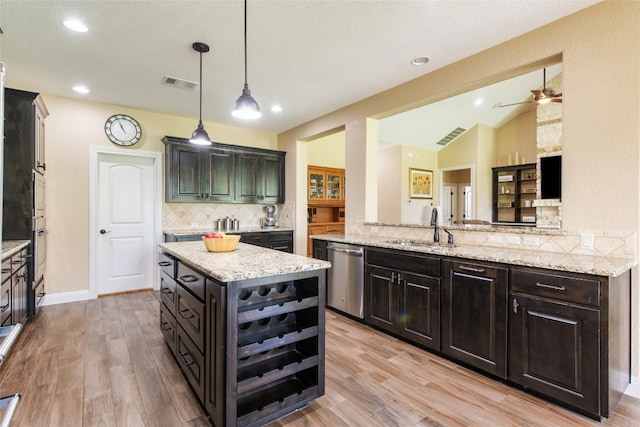 kitchen with sink, a center island, hanging light fixtures, stainless steel dishwasher, and backsplash