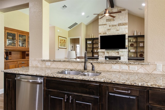 kitchen featuring dishwasher, sink, vaulted ceiling with beams, light stone counters, and backsplash