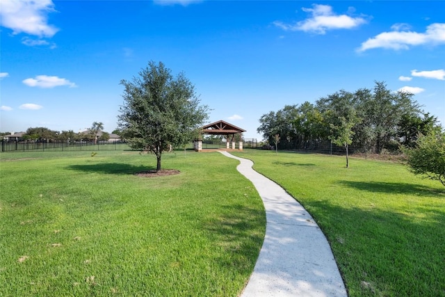 view of property's community with a yard, fence, and a gazebo