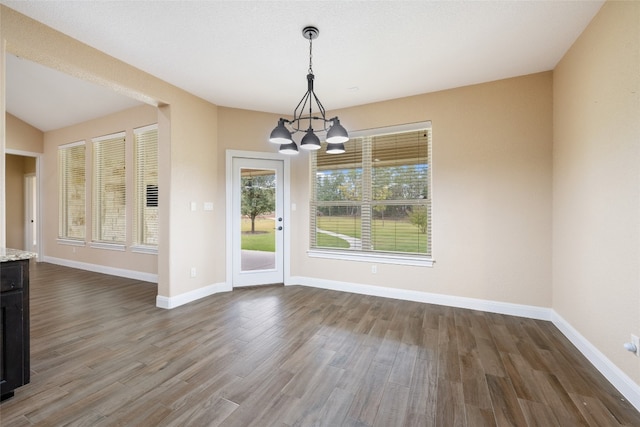 unfurnished dining area with hardwood / wood-style floors and a notable chandelier