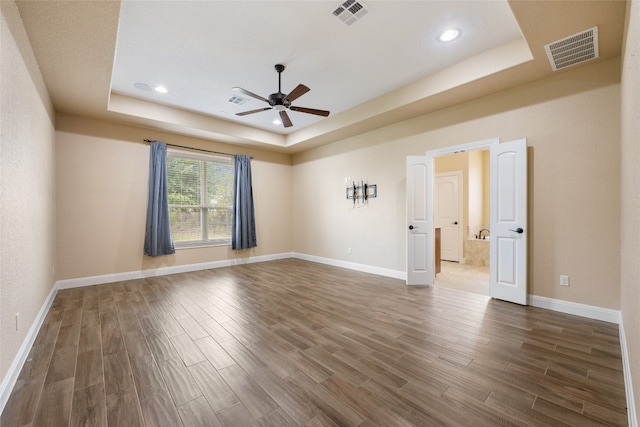 unfurnished room featuring ceiling fan and a tray ceiling