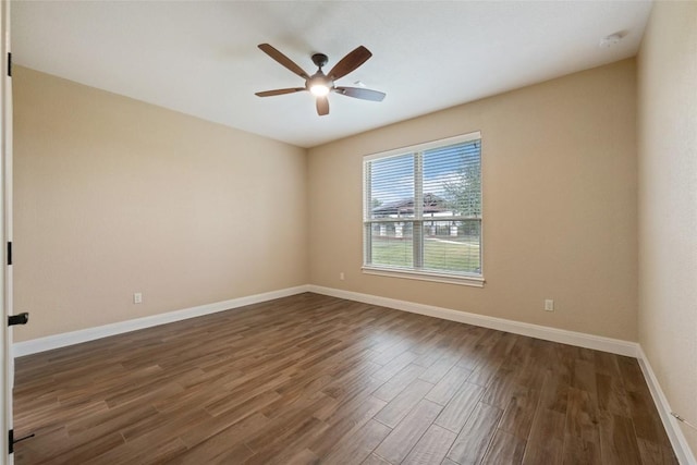 empty room featuring dark wood-style floors, baseboards, and a ceiling fan