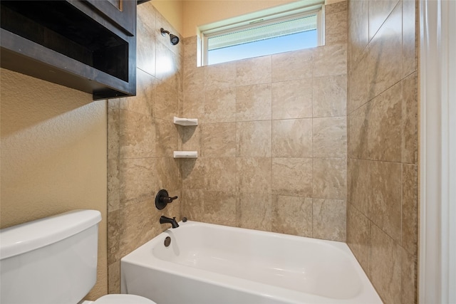 bathroom featuring tiled shower / bath and toilet