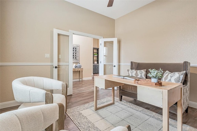 sitting room with a ceiling fan, baseboards, and wood finished floors