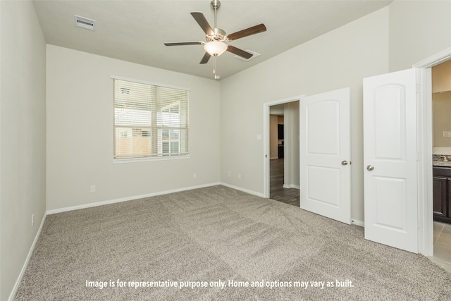 unfurnished bedroom featuring light colored carpet, connected bathroom, and ceiling fan