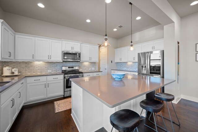 kitchen featuring appliances with stainless steel finishes, white cabinetry, and dark hardwood / wood-style flooring