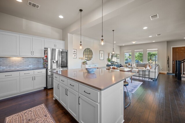 kitchen with a kitchen island, white cabinetry, stainless steel refrigerator with ice dispenser, and dark wood-type flooring