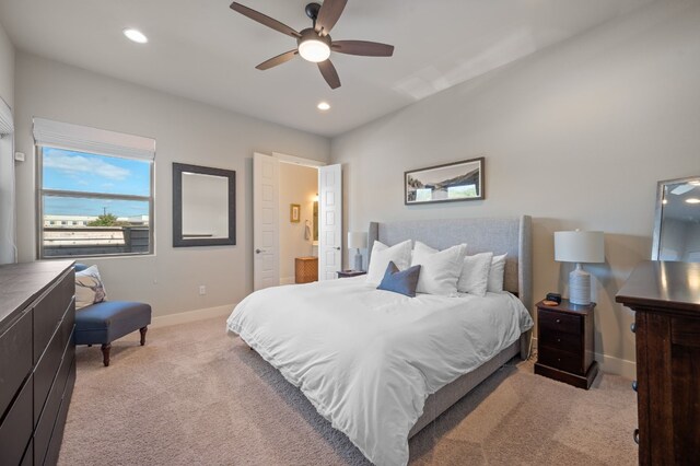 carpeted bedroom featuring ceiling fan and ensuite bathroom