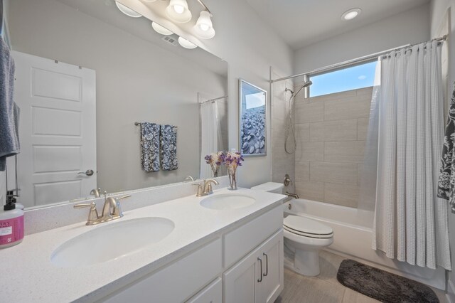 full bathroom featuring vanity, toilet, and shower / tub combo