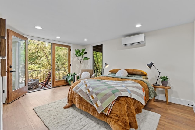 bedroom featuring light hardwood / wood-style flooring, access to exterior, and an AC wall unit