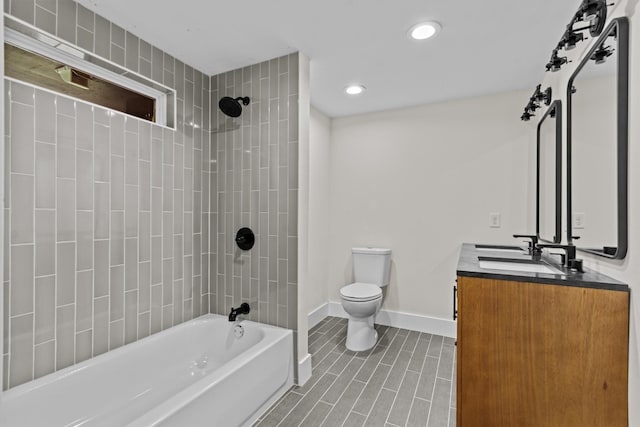 full bathroom featuring toilet, tiled shower / bath, and vanity