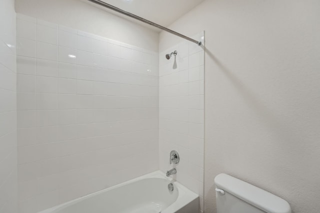 bathroom featuring tiled shower / bath and toilet