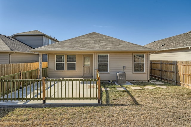 rear view of property with a yard and central AC