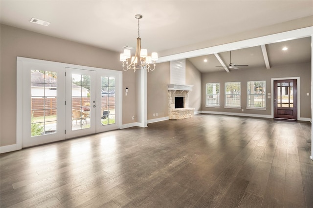 unfurnished living room featuring lofted ceiling with beams, dark hardwood / wood-style flooring, ceiling fan with notable chandelier, and a stone fireplace