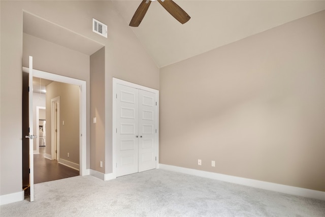 unfurnished bedroom featuring a closet, carpet floors, high vaulted ceiling, and ceiling fan