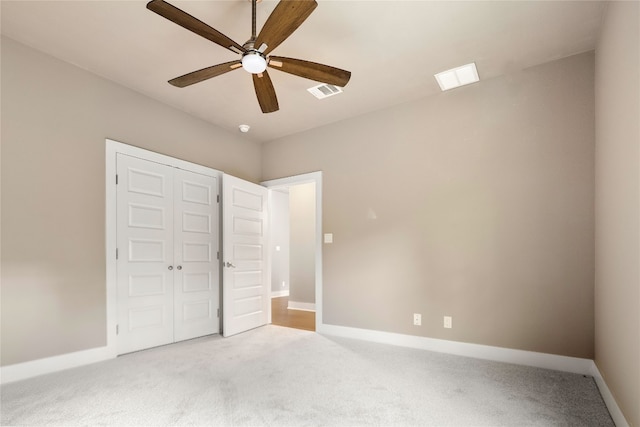 unfurnished bedroom with a closet, ceiling fan, and light carpet