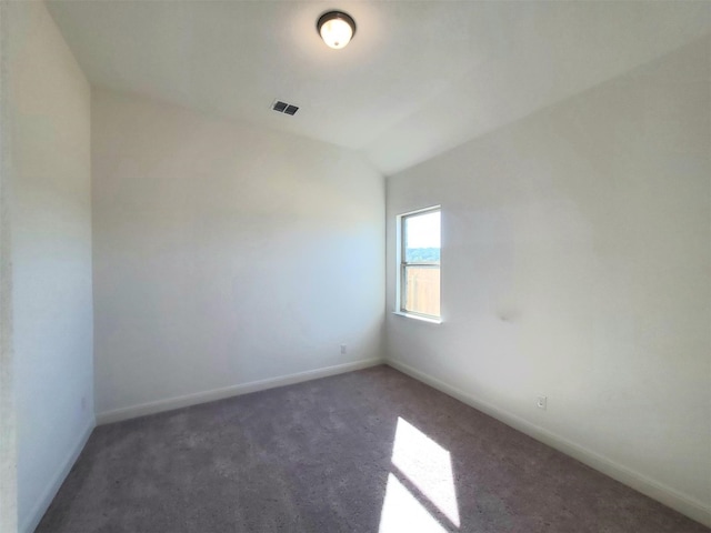 unfurnished room with dark carpet and lofted ceiling