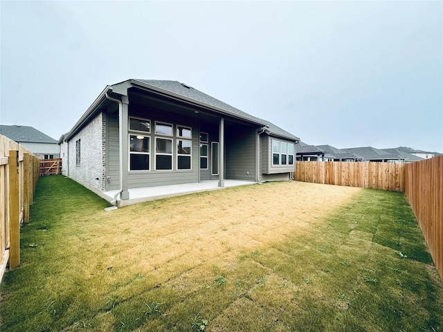 back of house featuring a patio area and a lawn