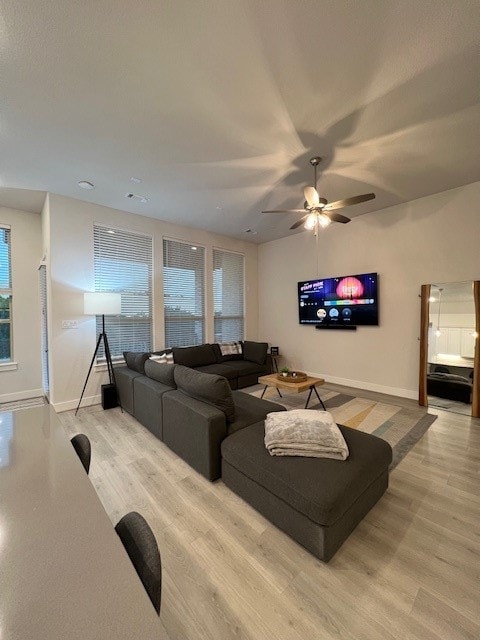 living room featuring light hardwood / wood-style flooring and ceiling fan