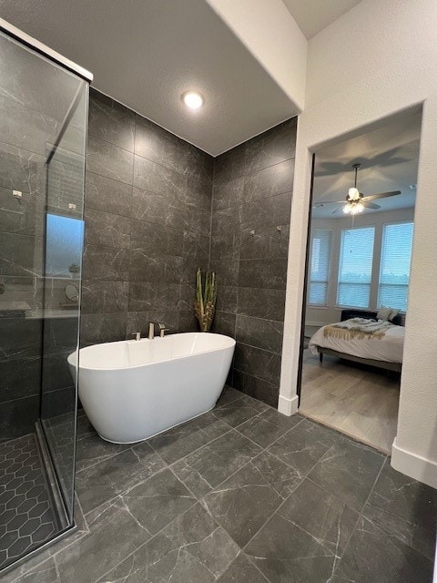 bathroom featuring ceiling fan, tile walls, and separate shower and tub