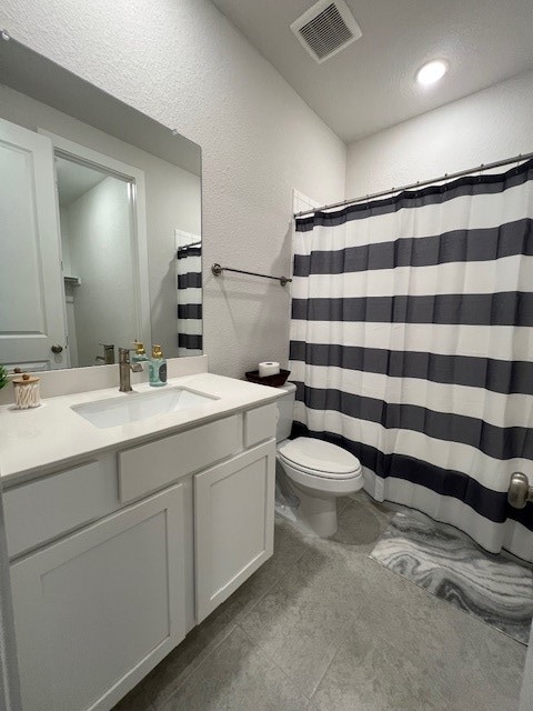 bathroom featuring vanity, a textured ceiling, a shower with curtain, and toilet