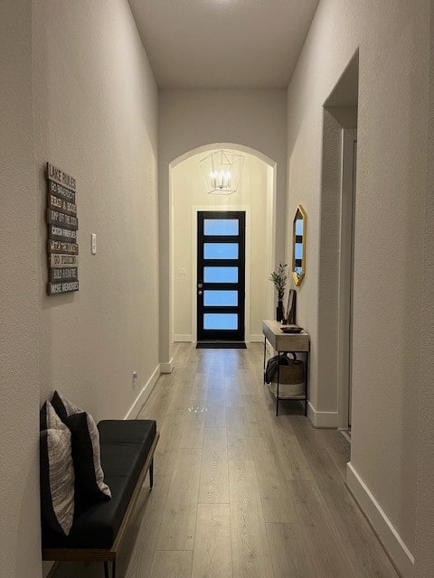 entryway with light hardwood / wood-style flooring and a notable chandelier