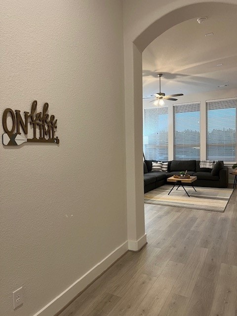 corridor with a wealth of natural light and hardwood / wood-style floors