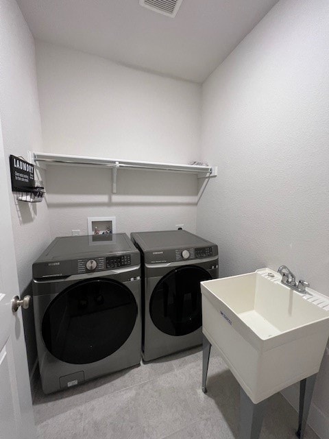 clothes washing area featuring sink and washer and clothes dryer