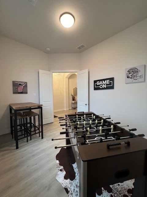 rec room featuring light hardwood / wood-style flooring and a textured ceiling