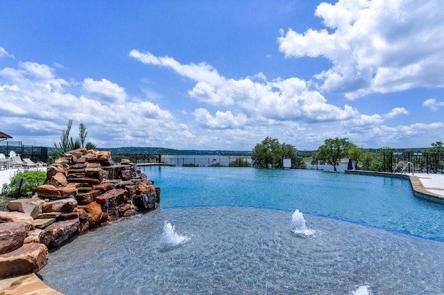 view of swimming pool featuring a water view and pool water feature