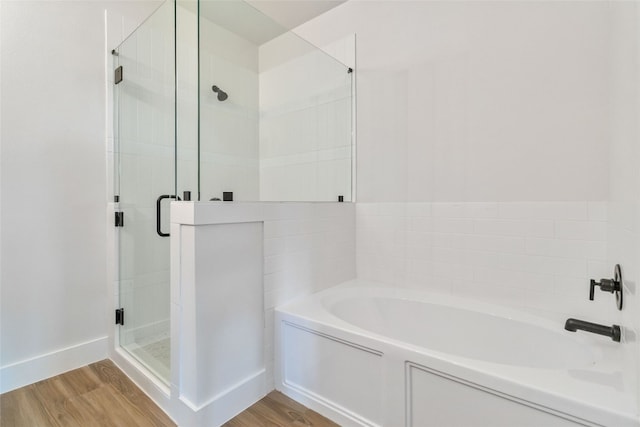 bathroom featuring hardwood / wood-style flooring and shower with separate bathtub